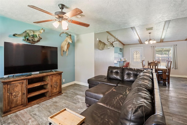 living area featuring wood finished floors, a textured ceiling, a chandelier, baseboards, and ceiling fan