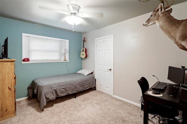 carpeted bedroom featuring baseboards, an office area, and ceiling fan
