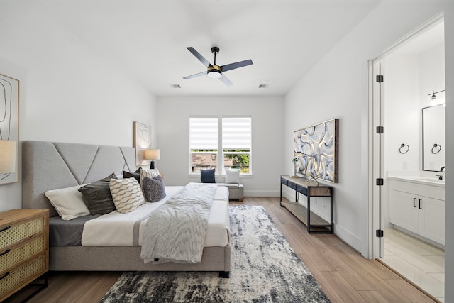 7117 Goforth St, Houston, TX 77021 - bedroom featuring light wood finished floors, ensuite bathroom, a sink, and ceiling fan