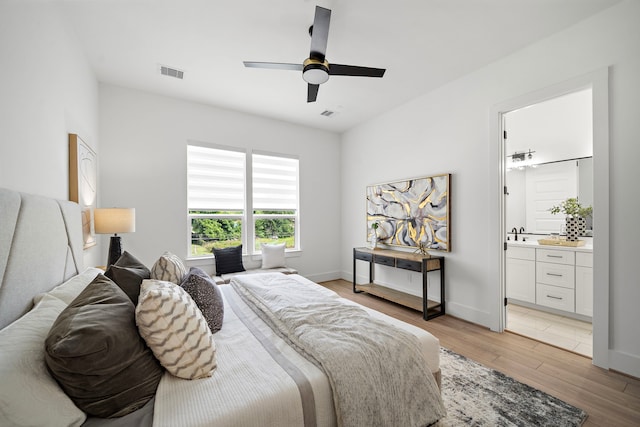 7117 Goforth St, Houston, TX 77021 - bedroom featuring light wood finished floors, ceiling fan, ensuite bathroom, and baseboards