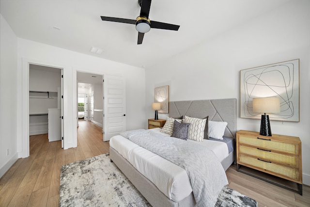 7117 Goforth St, Houston, TX 77021 - bedroom featuring light wood-type flooring, a spacious closet, baseboards, and a ceiling fan