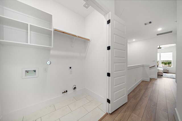 7117 Goforth St, Houston, TX 77021 - washroom featuring hookup for a gas dryer, hookup for an electric dryer, baseboards, hookup for a washing machine, and wood finished floors