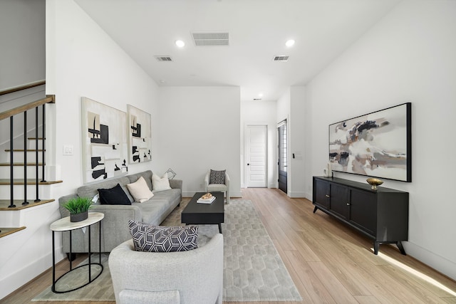 7117 Goforth St, Houston, TX 77021 - living room featuring stairway, light wood finished floors, baseboards, and recessed lighting