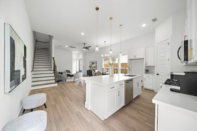 7117 Goforth St, Houston, TX 77021 - kitchen with stainless steel appliances, light wood-type flooring, light countertops, a sink, and ceiling fan