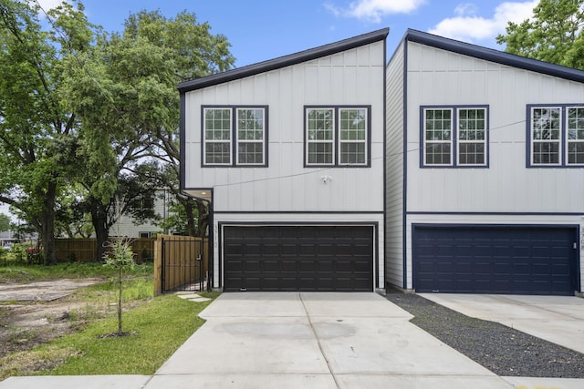 3710 Noah St, Houston, TX 77021 - view of front facade with a garage, driveway, fence, and board and batten siding