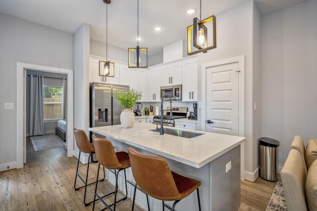 3710 Noah St, Houston, TX 77021 - kitchen with stainless steel appliances, baseboards, white cabinetry, a breakfast bar area, and light wood-style floors