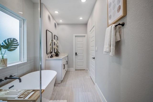 3710 Noah St, Houston, TX 77021 - bathroom with vanity, a freestanding tub, recessed lighting, and baseboards