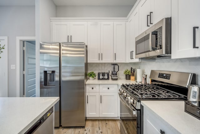 3710 Noah St, Houston, TX 77021 - kitchen with appliances with stainless steel finishes, light countertops, white cabinets, and backsplash