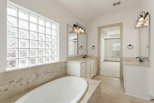 67 Quiet Vista Dr, Sugar Land, TX 77498 - bathroom with healthy amount of natural light, a tub with jets, two vanities, and vaulted ceiling