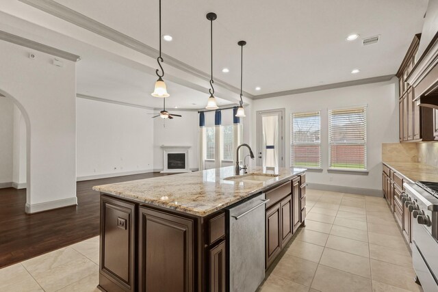 67 Quiet Vista Dr, Sugar Land, TX 77498 - kitchen with stainless steel dishwasher, a sink, arched walkways, baseboards, and a ceiling fan