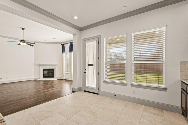 67 Quiet Vista Dr, Sugar Land, TX 77498 - unfurnished living room featuring crown molding, a glass covered fireplace, a ceiling fan, healthy amount of natural light, and recessed lighting