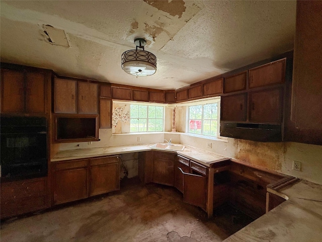 40736 Jozwiak Ln, Hempstead, TX 77445 - kitchen with a sink, under cabinet range hood, unfinished concrete floors, a textured ceiling, and light countertops