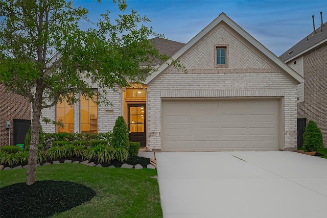 view of front of house with a garage, driveway, brick siding, and a front yard