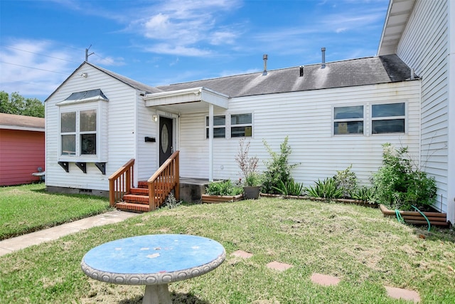5311 Perry Ave, Galveston, TX 77551 - rear view of property featuring a lawn and roof with shingles