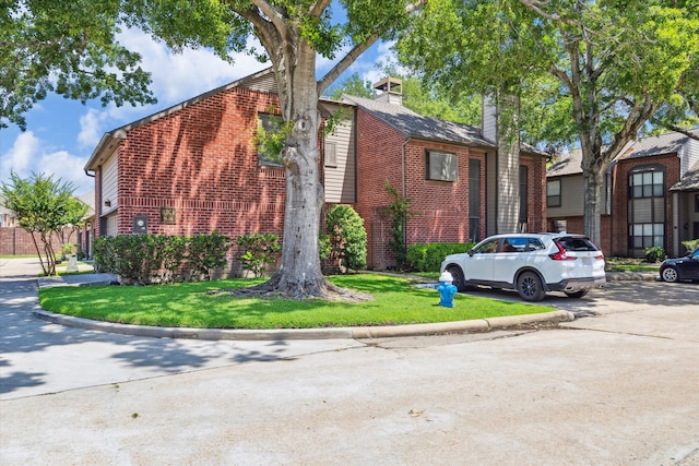 7447 Cambridge St Unit 75, Houston, TX 77054 - view of side of property featuring brick siding, a chimney, and a yard