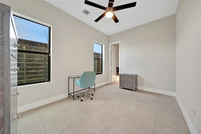 unfurnished office featuring plenty of natural light, ceiling fan, tile patterned flooring, and baseboards
