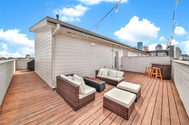 wooden terrace featuring an outdoor living space with a fire pit