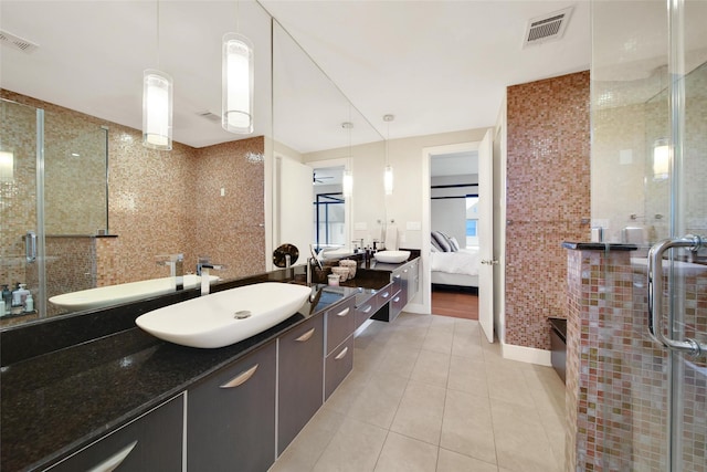 bathroom featuring tile patterned floors, connected bathroom, a stall shower, vanity, and tile walls