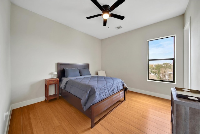 bedroom with baseboards, light wood-type flooring, and a ceiling fan