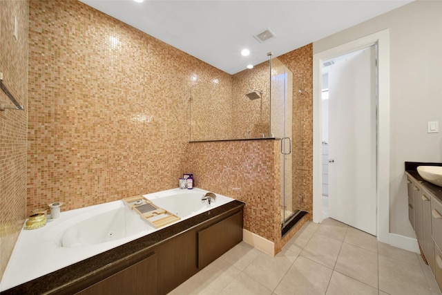 full bathroom featuring a tub with jets, tile walls, a stall shower, tile patterned flooring, and vanity