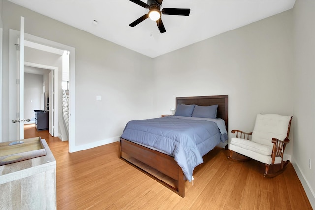 bedroom featuring light wood-style floors, baseboards, and ceiling fan