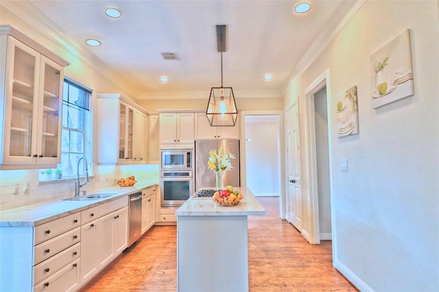 3628 Timberside Circle Dr, Houston, TX 77025 - kitchen with appliances with stainless steel finishes, a sink, crown molding, a center island, and backsplash