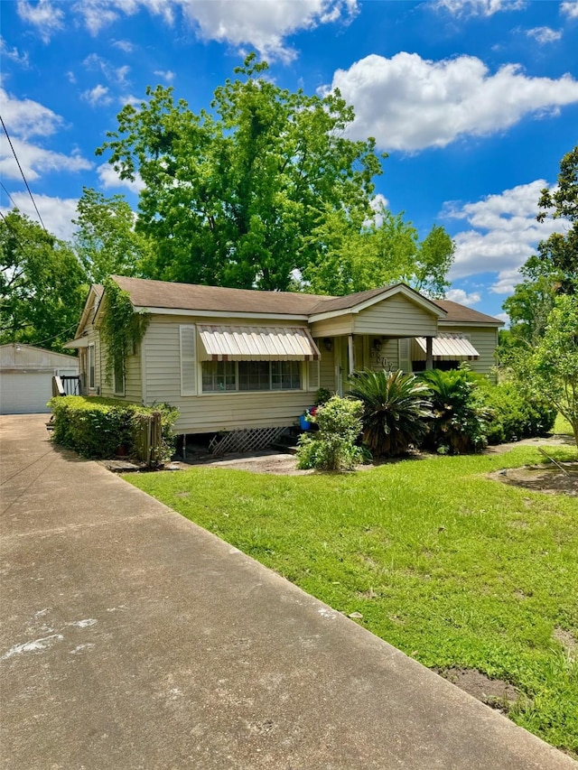 view of front of home featuring a front yard, an outdoor structure, and a garage