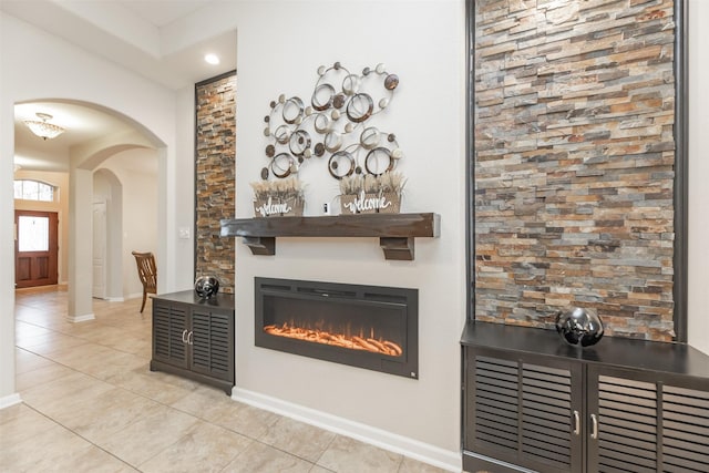 19315 S Cottonwood Green Ln, Cypress, TX 77433 - living room featuring light tile patterned flooring, arched walkways, baseboards, a glass covered fireplace, and recessed lighting