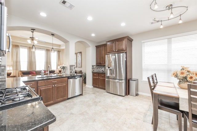 19315 S Cottonwood Green Ln, Cypress, TX 77433 - kitchen with appliances with stainless steel finishes, a sink, arched walkways, a ceiling fan, and baseboards