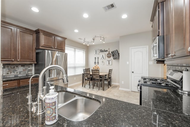 19315 S Cottonwood Green Ln, Cypress, TX 77433 - kitchen with appliances with stainless steel finishes, a sink, decorative backsplash, dark stone counters, and recessed lighting