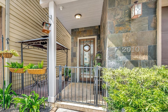 2010 Sabine St, Houston, TX 77007 - doorway to property featuring covered porch and stone siding