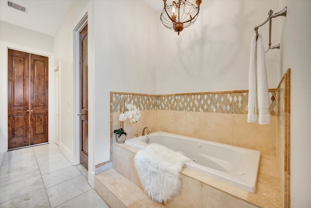 2010 Sabine St, Houston, TX 77007 - bathroom with a jetted tub, a chandelier, and marble finish flooring