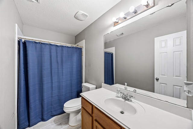 bathroom with toilet, wood finished floors, vanity, a textured ceiling, and a shower with curtain