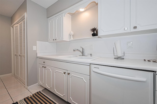 kitchen featuring dishwasher, a sink, white cabinets, light tile patterned floors, and light countertops