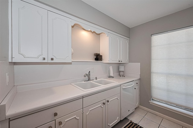 kitchen with white dishwasher, a sink, light tile patterned flooring, white cabinetry, and light countertops