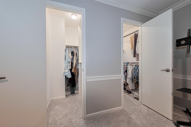 hall featuring baseboards, ornamental molding, and carpet flooring