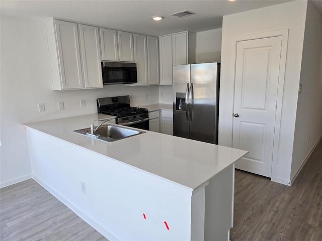444 Shoreview Dr, Conroe, TX 77303 - kitchen featuring stainless steel appliances, a sink, wood finished floors, light countertops, and recessed lighting