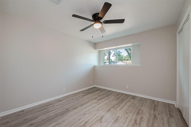 empty room with wood finished floors, baseboards, and a ceiling fan