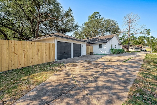 view of home's exterior with fence, driveway, and board and batten siding