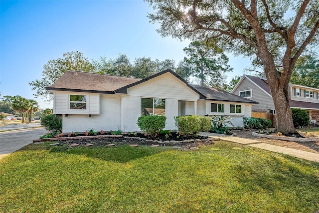 view of front of home featuring brick siding and roof with shingles