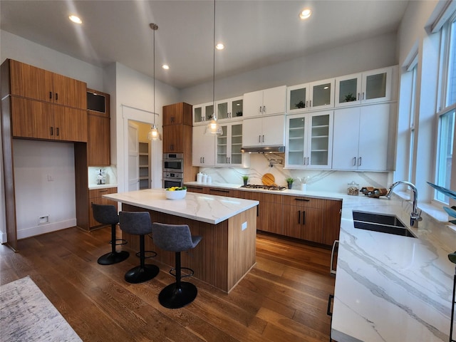 3308 Cardinal Crest Ln, Houston, TX 77080 - kitchen with a sink, dark wood-type flooring, a center island, brown cabinets, and recessed lighting