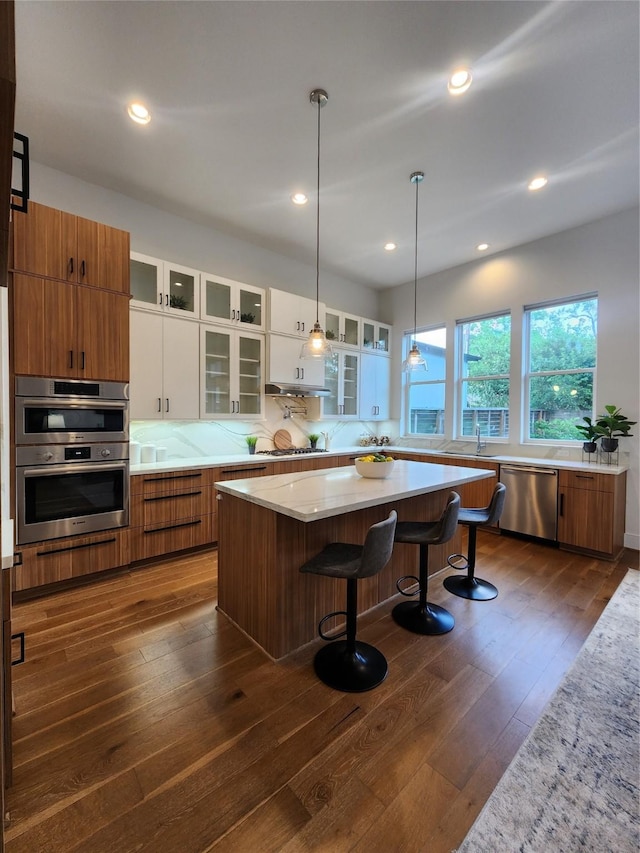 3308 Cardinal Crest Ln, Houston, TX 77080 - kitchen featuring stainless steel appliances, dark wood-style floors, white cabinets, a center island, and glass insert cabinets