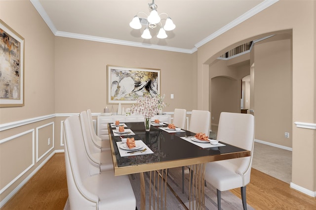 13607 Summer Hill Dr, Montgomery, TX 77356 - dining space with wood finished floors, a chandelier, arched walkways, and crown molding