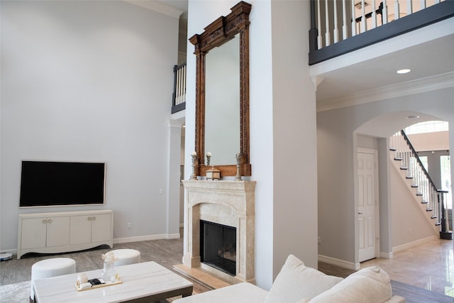 5065 Oakmont Dr, Beaumont, TX 77706 - living area with a towering ceiling, crown molding, stairway, baseboards, and a fireplace