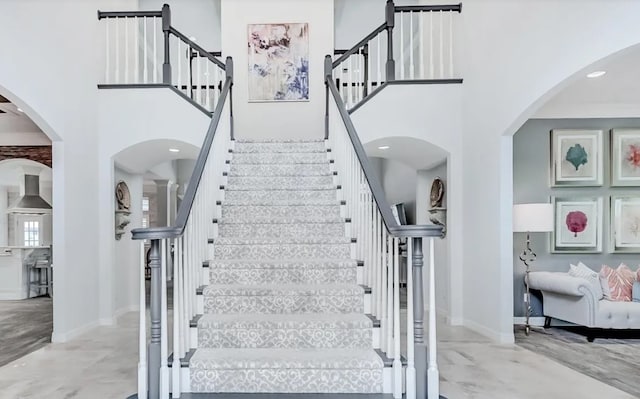 5065 Oakmont Dr, Beaumont, TX 77706 - staircase with a high ceiling, baseboards, and arched walkways