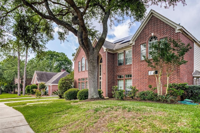 4011 N Water Iris Ct, Houston, TX 77059 - view of property exterior featuring brick siding, solar panels, and a lawn