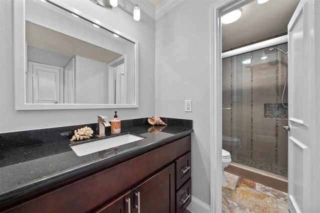 3402 Garrott St Unit 13, Houston, TX 77006 - bathroom featuring stone tile flooring, a shower stall, toilet, vanity, and ornamental molding