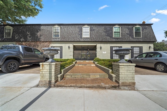 3402 Garrott St Unit 13, Houston, TX 77006 - townhome / multi-family property with mansard roof, a shingled roof, brick siding, and driveway