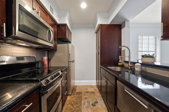 3402 Garrott St Unit 13, Houston, TX 77006 - kitchen featuring stainless steel appliances, a sink, crown molding, baseboards, and stone tile floors