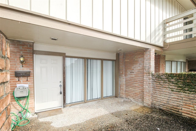 entrance to property featuring brick siding and board and batten siding